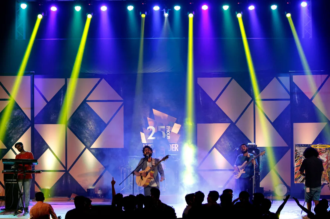 Banda se apresentando num palco com painel de LED ao fundo